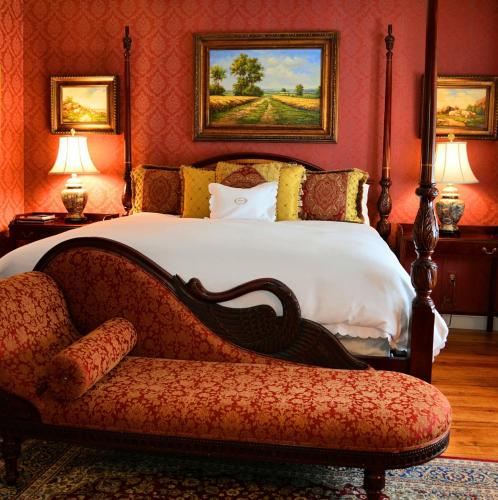 a bedroom with a bed and a couch and a chair at Antrim 1844 in Taneytown