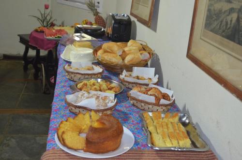 un tavolo con vari prodotti da forno e pane di Pousada Rancho da Mata a Conservatória