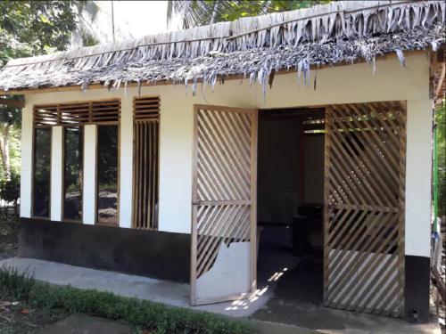 a small house with a thatched roof at Susan Homestay in Batukaras