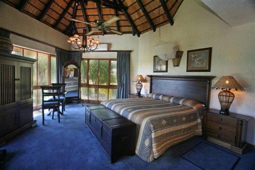 een slaapkamer met een groot bed en een eetkamer bij Kruger Park Lodge 401 in Hazyview