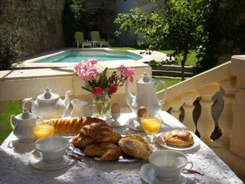 einen Tisch mit einem Frühstück mit Gebäck und Orangensaft in der Unterkunft Les Saisons in Villeneuve-lès-Avignon