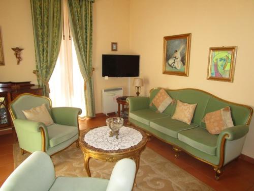 a living room with two green couches and a table at Quinta Outeiro da Luz in Branca