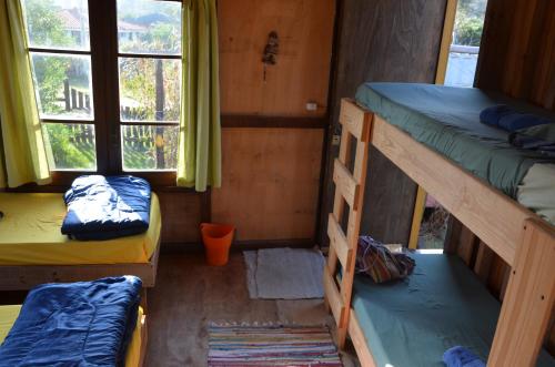 a room with two bunk beds and a window at La Brújula Hostel in La Paloma
