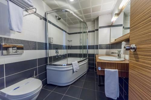 Un baño con bañera, inodoro y lavabo. en Hotel Almina Park, en Duzce