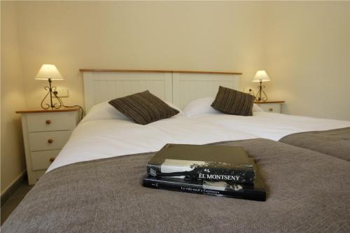 a book sitting on top of two beds at Apartaments Rural Montseny in gualba de Dalt