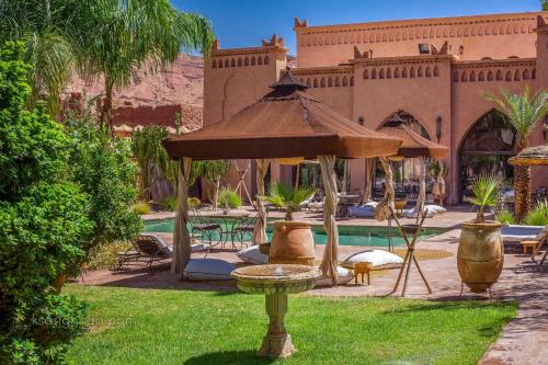 a fountain in the grass next to a pool at Ksar Ighnda in Aït Ben Haddou