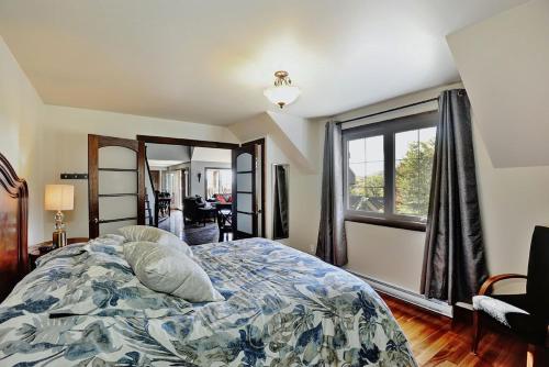 a bedroom with a bed and a large window at Chalet 01 Chemin Blanc by Les Chalets Alpins in Stoneham