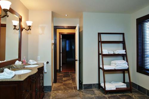 La salle de bains est pourvue d'un lavabo et d'une étagère avec des serviettes. dans l'établissement Chalet 01 Chemin Blanc by Les Chalets Alpins, à Stoneham