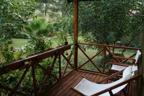 a balcony with two chairs and a garden at Kibala Hotel in Cıralı