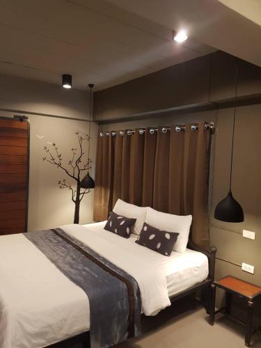 a bedroom with a bed with black and white pillows at Duangdren Place in Chiang Mai