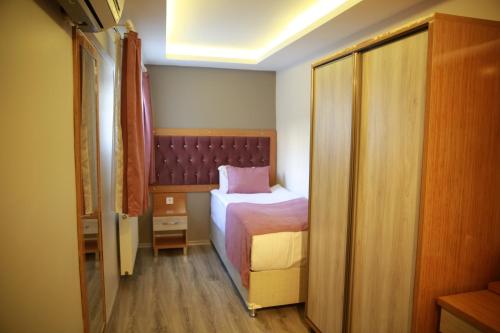 a small bedroom with a bed and a closet at Hotel Black Pearl in Istanbul