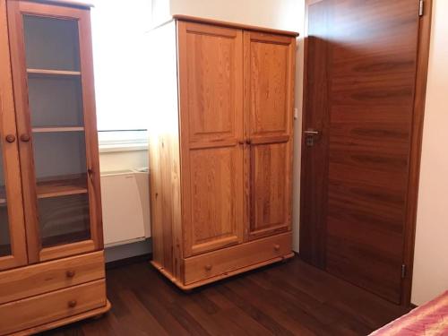 a bedroom with a closet and a wooden cabinet at Kukucinova Apartments in Bratislava