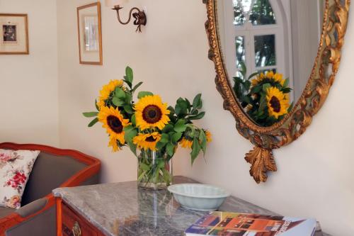 a vase of sunflowers on a table with a mirror at Casa Holstein Quinta de Sao Sebastiao Sintra in Sintra