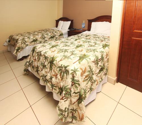 a hotel room with two beds with a comforter at Hotel Florencia in San Miguel