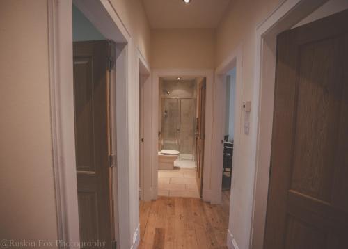 a hallway of a bathroom with a toilet and a tub at Apartment B in Aberdeen