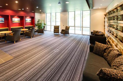 a waiting room with a couch and tables and chairs at Aparion Apartments Berlin in Berlin