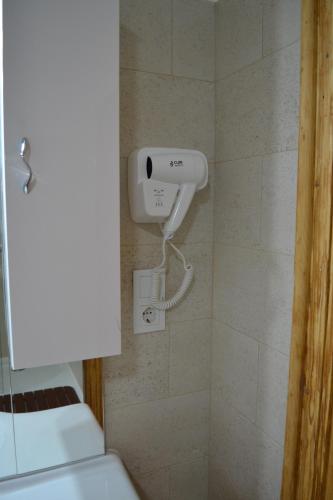 a shower in a bathroom with a hair dryer on the wall at Casa Fanarilor in Braşov