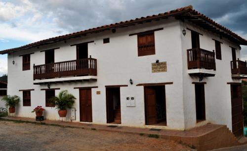 a white building with wooden doors and windows at Hospedaje Donde Lorenzo in Barichara