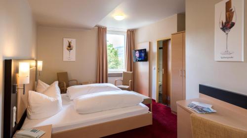 a hotel room with two beds and a window at Rheinhotel Lamm in Rüdesheim am Rhein