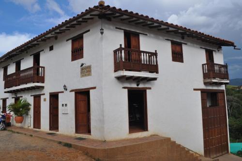 a white building with wooden doors and balconies at Hospedaje Donde Lorenzo in Barichara