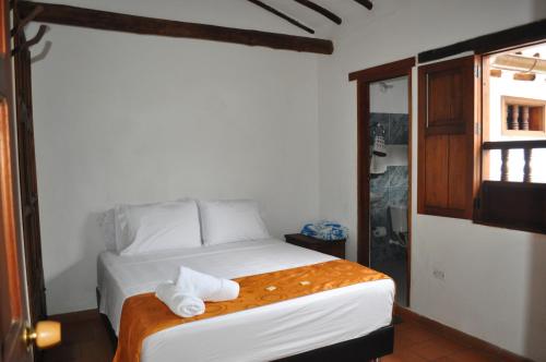 a bedroom with a bed with two towels on it at Hospedaje Donde Lorenzo in Barichara