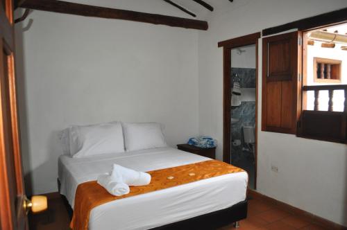 a bedroom with a bed with towels on it at Hospedaje Donde Lorenzo in Barichara