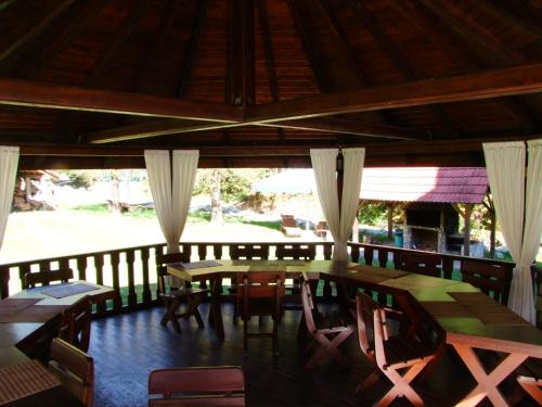 ein Esszimmer mit Tischen und Stühlen auf einer Veranda in der Unterkunft Vila Ursul in Ciungetu