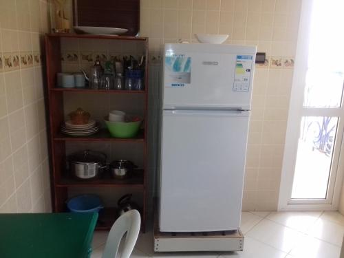 a white refrigerator in a kitchen next to a shelf at Résidence La Galiote in Essaouira