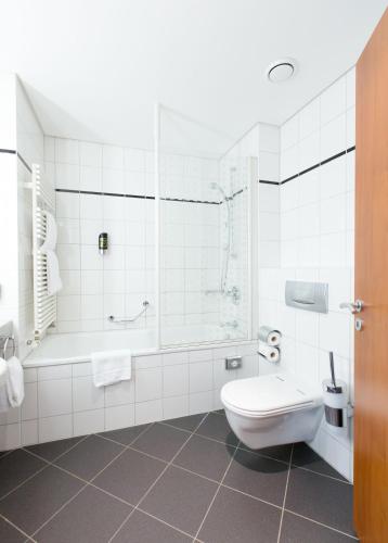 a white bathroom with a toilet and a shower at Aparion Apartments Berlin in Berlin