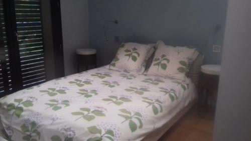 uma cama com um edredão branco e almofadas em Maison passive et d'architecte em Treillières
