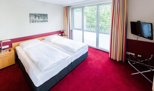 a hotel room with a bed and a television at Aparion Apartments Berlin in Berlin