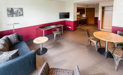 a living room with a couch and a table and chairs at Aparion Apartments Berlin in Berlin