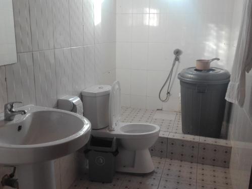 ein Badezimmer mit einem WC, einem Waschbecken und einem Mülleimer in der Unterkunft IS Guest House in Cape Coast