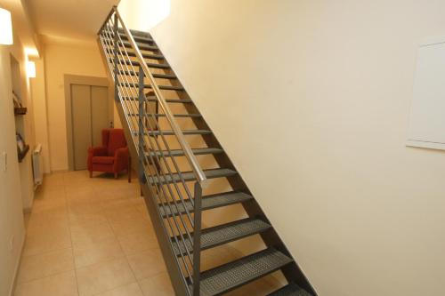 a spiral staircase in a room with a red chair at Cal Metge de Gualba in gualba de Dalt
