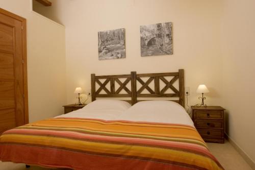 a bedroom with a bed with two lamps and two pictures at Cal Metge de Gualba in gualba de Dalt