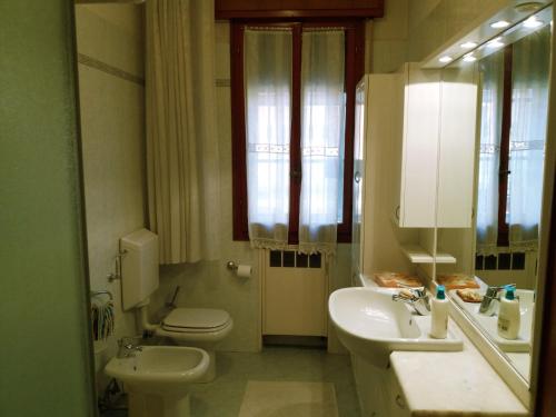 a bathroom with two sinks and a toilet and a mirror at Bed & Breakfast Anzola in Anzola dell'Emilia