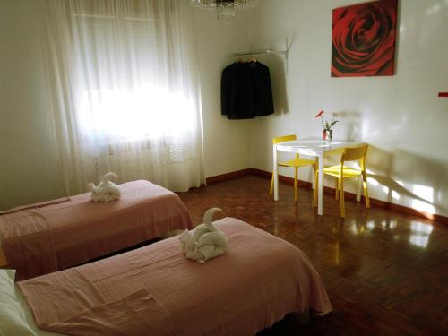 a room with two beds and a table and a window at Bed & Breakfast Anzola in Anzola dell'Emilia