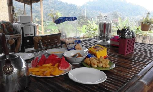 a table with plates of food on top at De Salak Homestay in Bogor