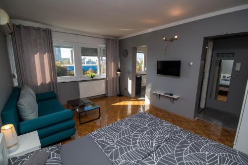 een woonkamer met een blauwe bank en een televisie bij Apartment Barnjak - Novi Zagreb in Zagreb
