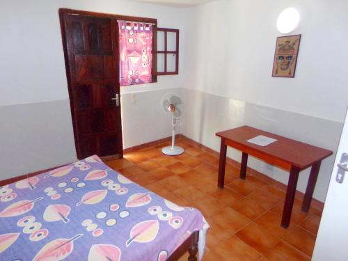 a room with a bed and a table and a door at Hôtel Katakalousse in Yembakana