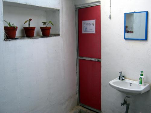 a bathroom with a red door and a sink at Friends in Khajuraho in Khajurāho