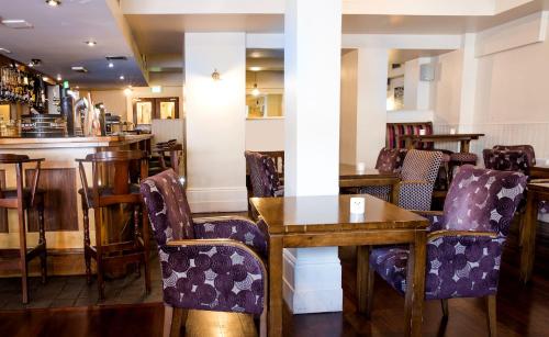 a restaurant with tables and chairs and a bar at The Gateway Hotel in Swinford