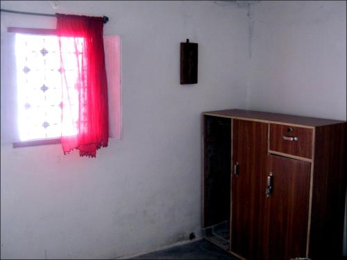 a room with a red curtain and a window at Friends in Khajuraho in Khajurāho