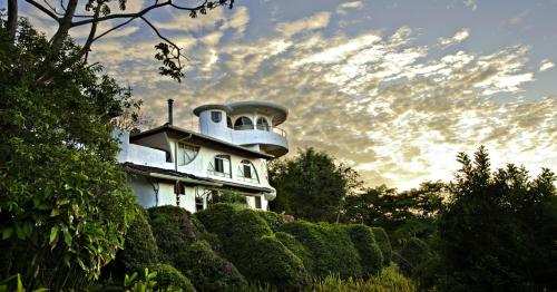 a white house with a tower on top of it at Finca Rosa Blanca Coffee Farm and Inn in Heredia