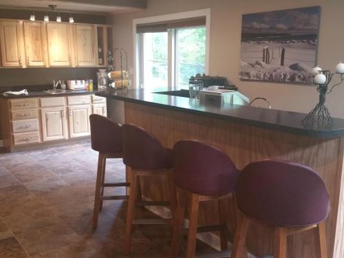 a kitchen with a counter with chairs around it at Elegant 2 King Bedrooms Apartment - 4 guest maximum and2 night minimum in Traverse City