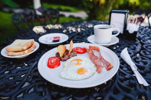 a plate of eggs and bacon and bread on a table at Hotel Colon Merida in Mérida