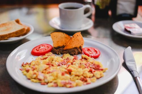 a plate of food with tomatoes and toast on a table at Hotel Colon Merida in Mérida