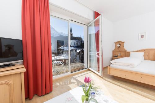 a bedroom with a bed and a large window at Hotel Restaurant GABRIEL in Scuol