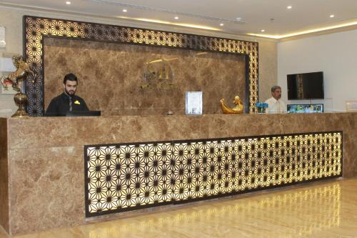 Un uomo seduto in un bar nella hall di un hotel di Rayat Al Shalal Hotel a Hafr Al Baten