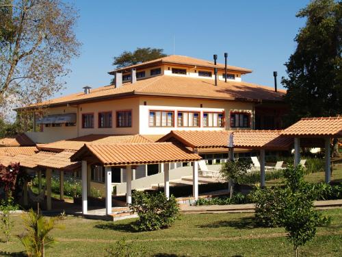 a large building with tile roofs on top of a yard at Hotel Fazenda Itáytyba in Tibagi